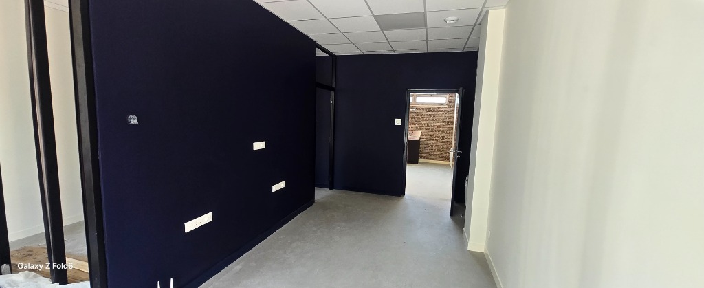Bureaux tertiaires rénovés avec cloison bleu nuit, appareillage blanc encastré et dalles 60x60